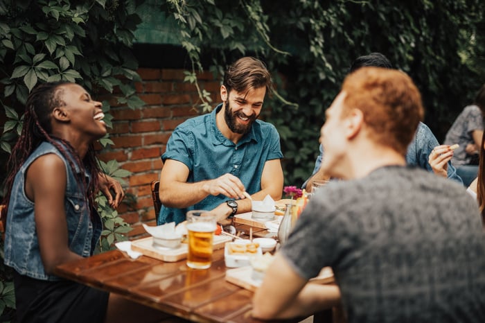 Friends enjoying a meal and laughing. 