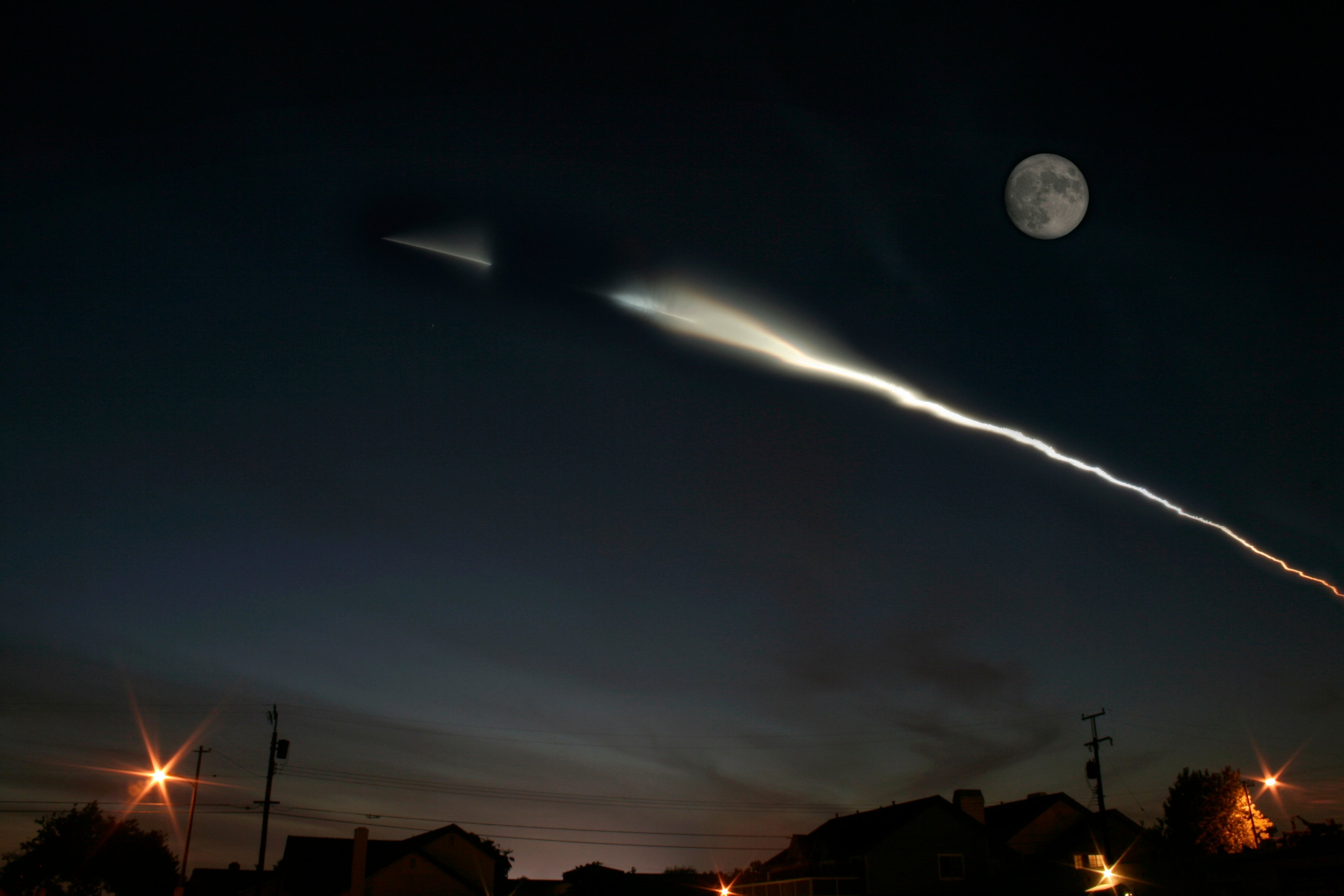 A rocket launch at night, seen from the ground.
