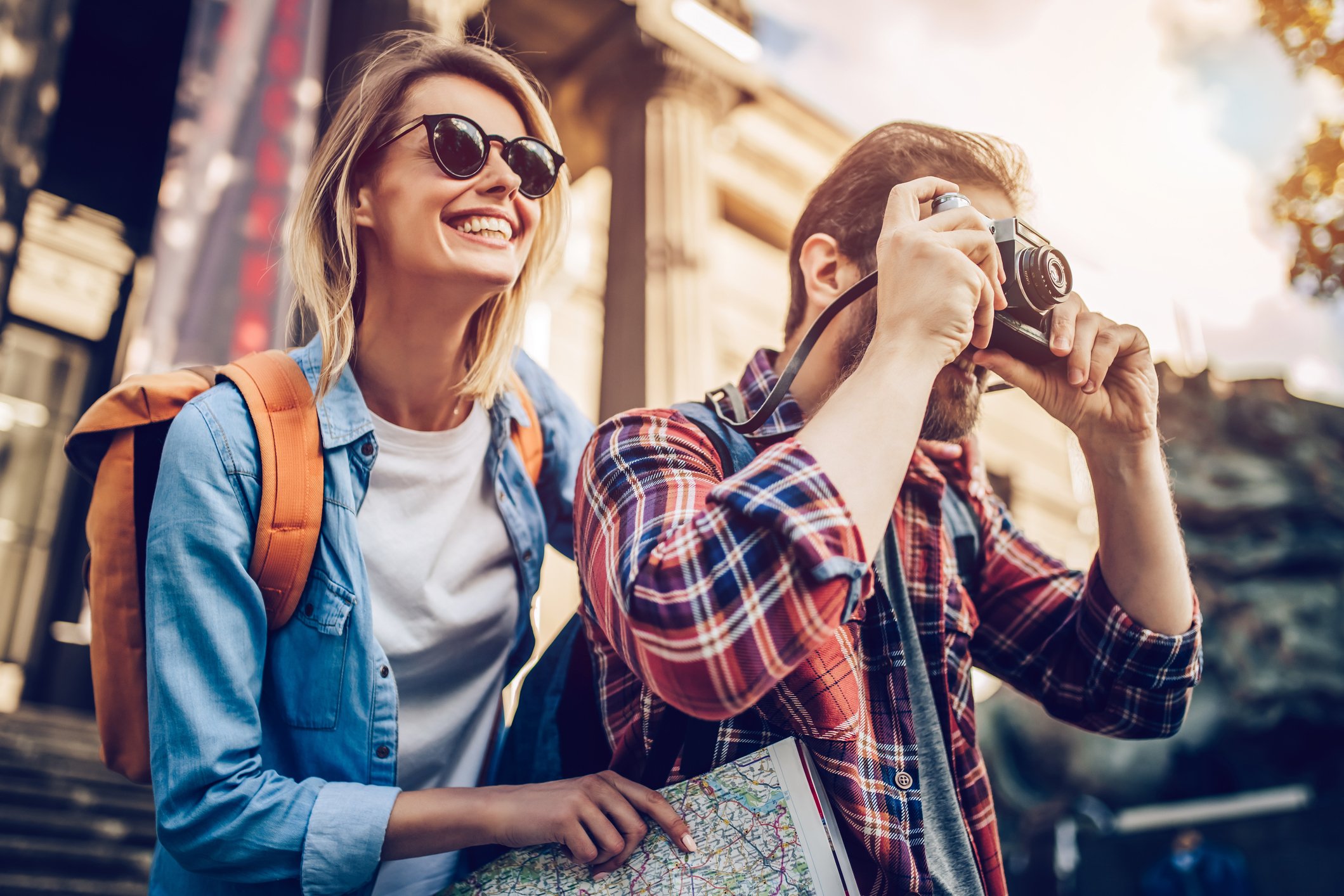 Two travelers smiling and taking pictures.