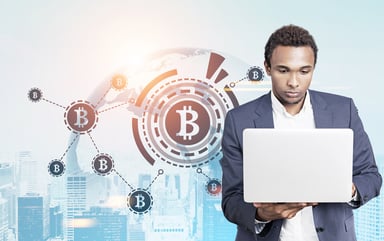 Bitcoin symbols with man looking at laptop