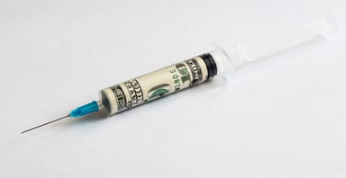 Vaccine syringe with $100 bill in it