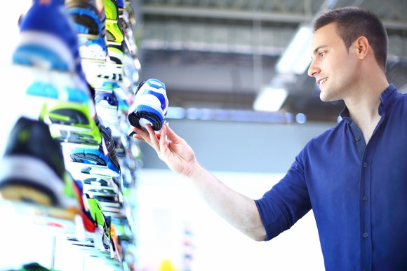 A young man checks out sneakers at a store.