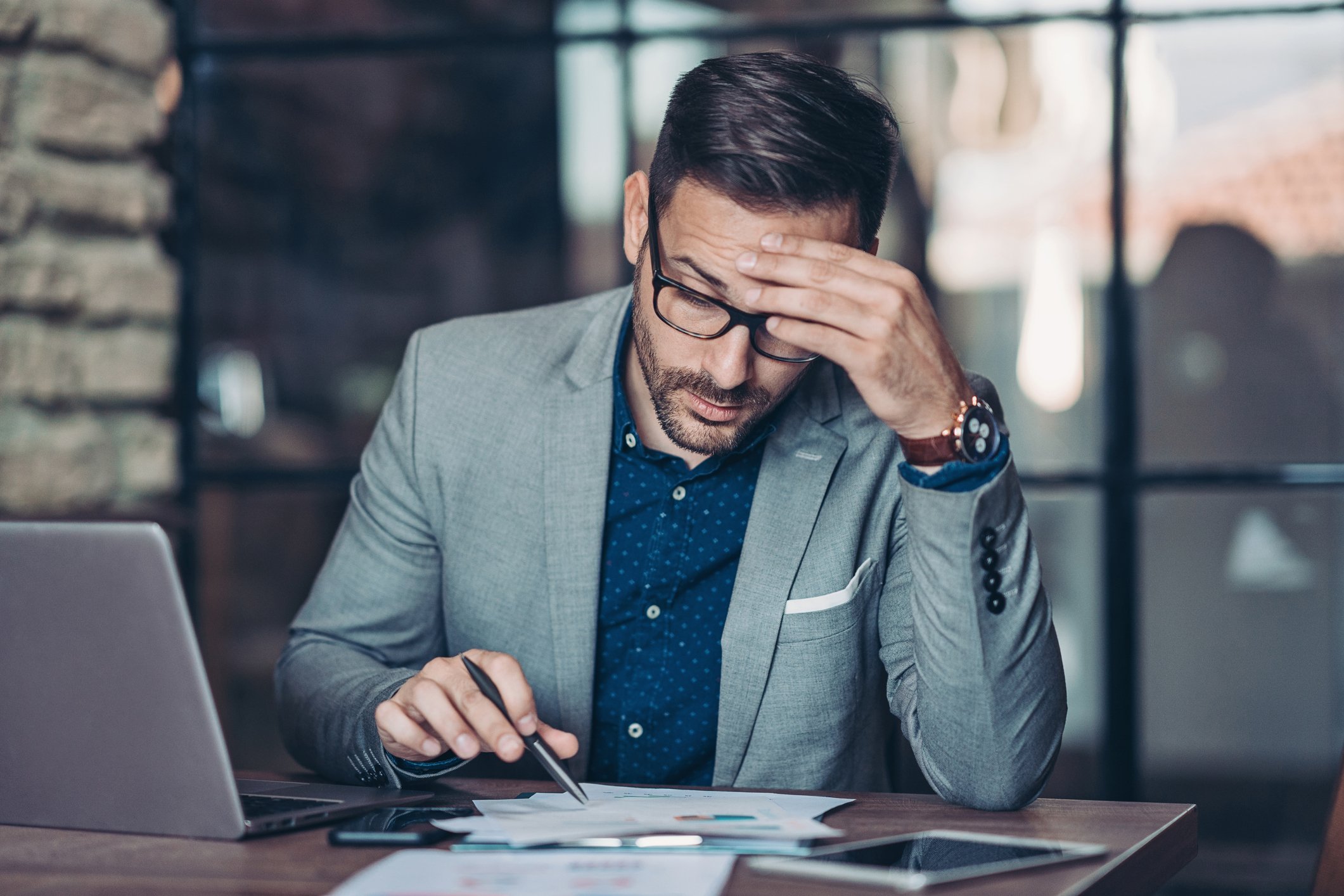 Concerned man looking at papers on a desk.