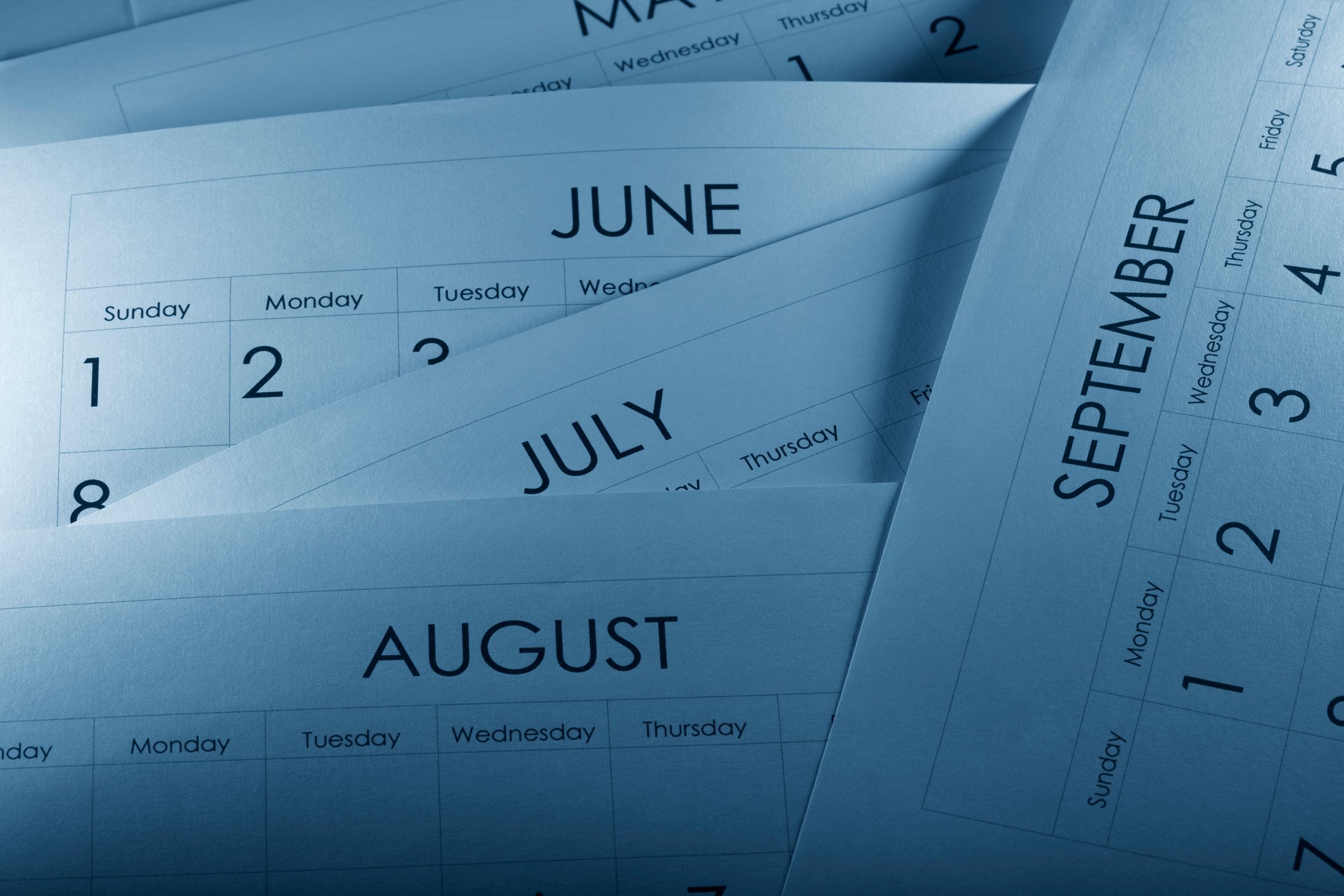 Printed monthly calendars lying on top of one another.