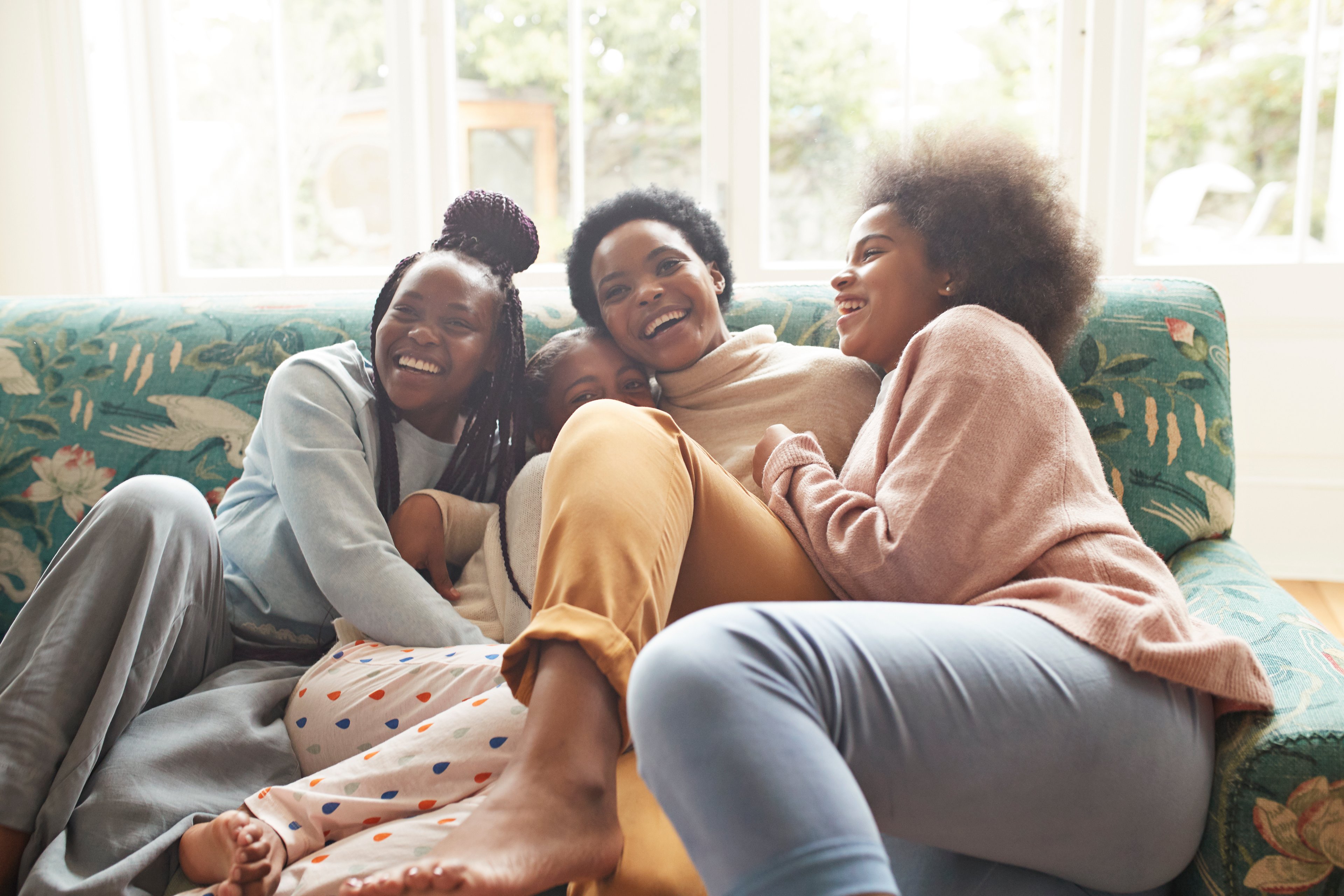Happy women in loungewear on couch.