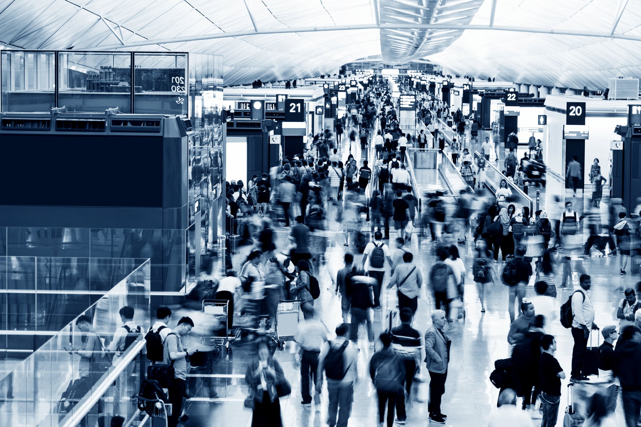 Huge crowds in a busy airport terminal.