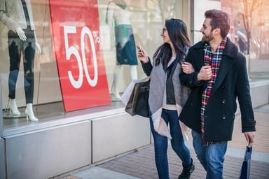 couple shopping for clothing through store window