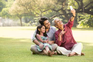 3 generations taking a selfie in the park