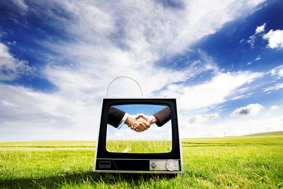 A TV display showing two businesspeople shaking hands.