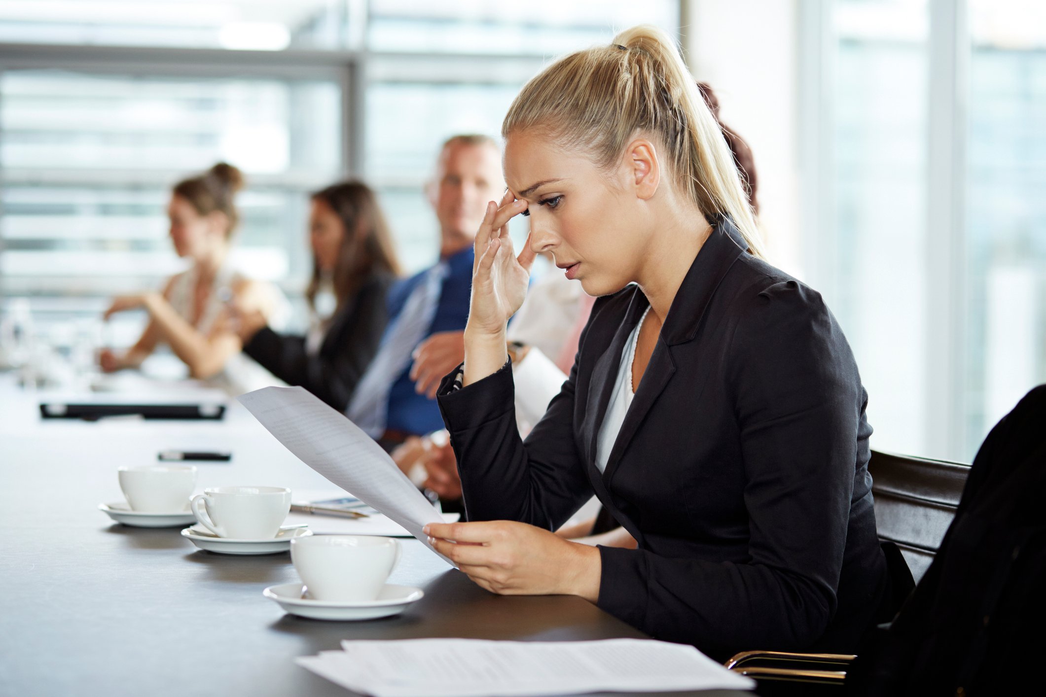 A business woman looking concerned as she looks at a document. 