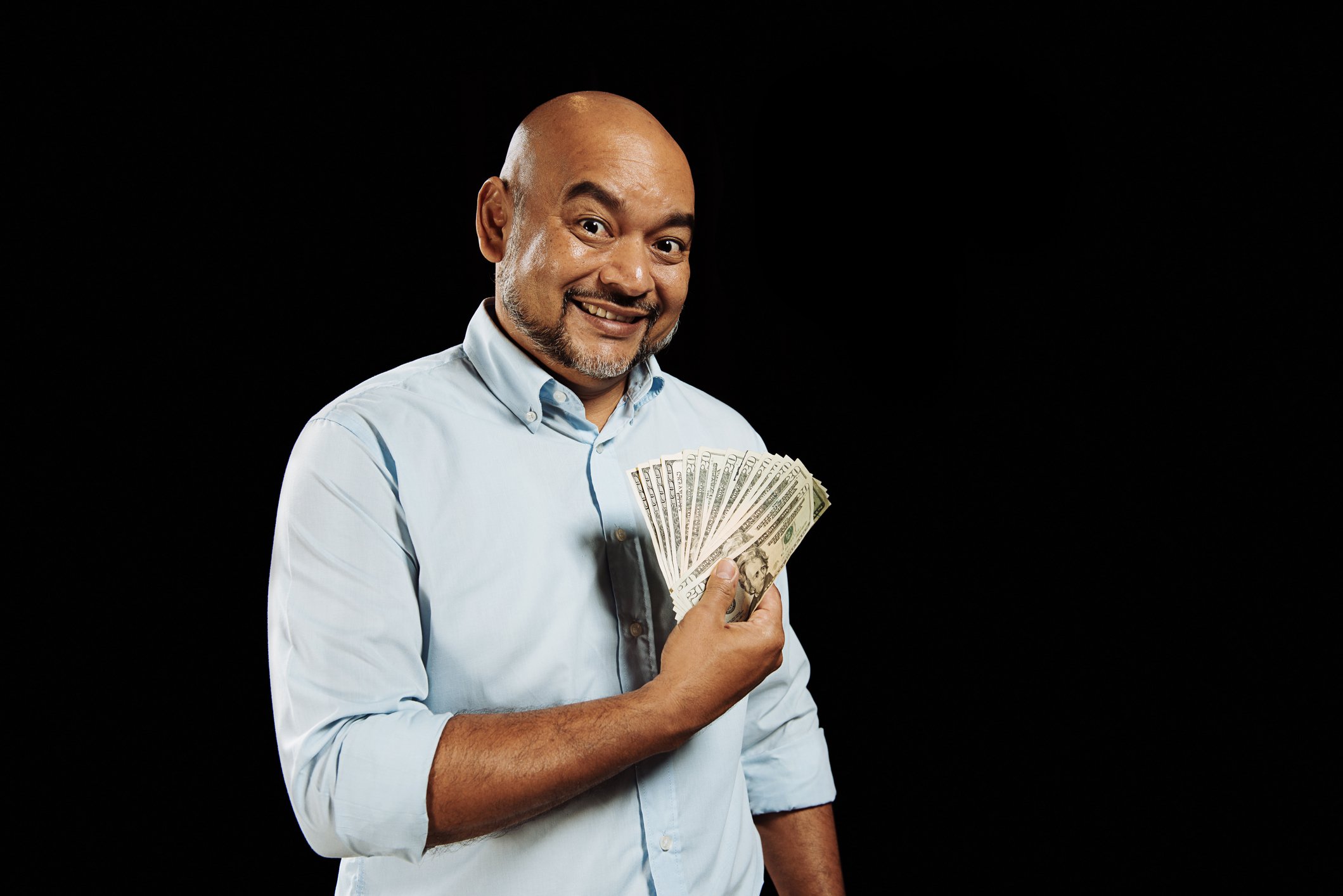 Getty - man with cash, dividends money income happy