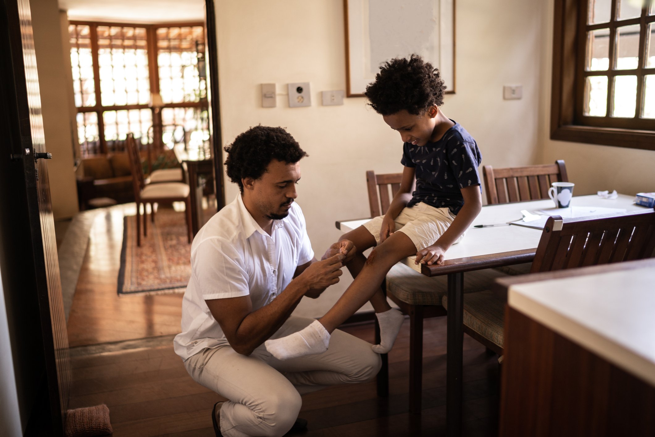 Man attending to a child's leg injury.