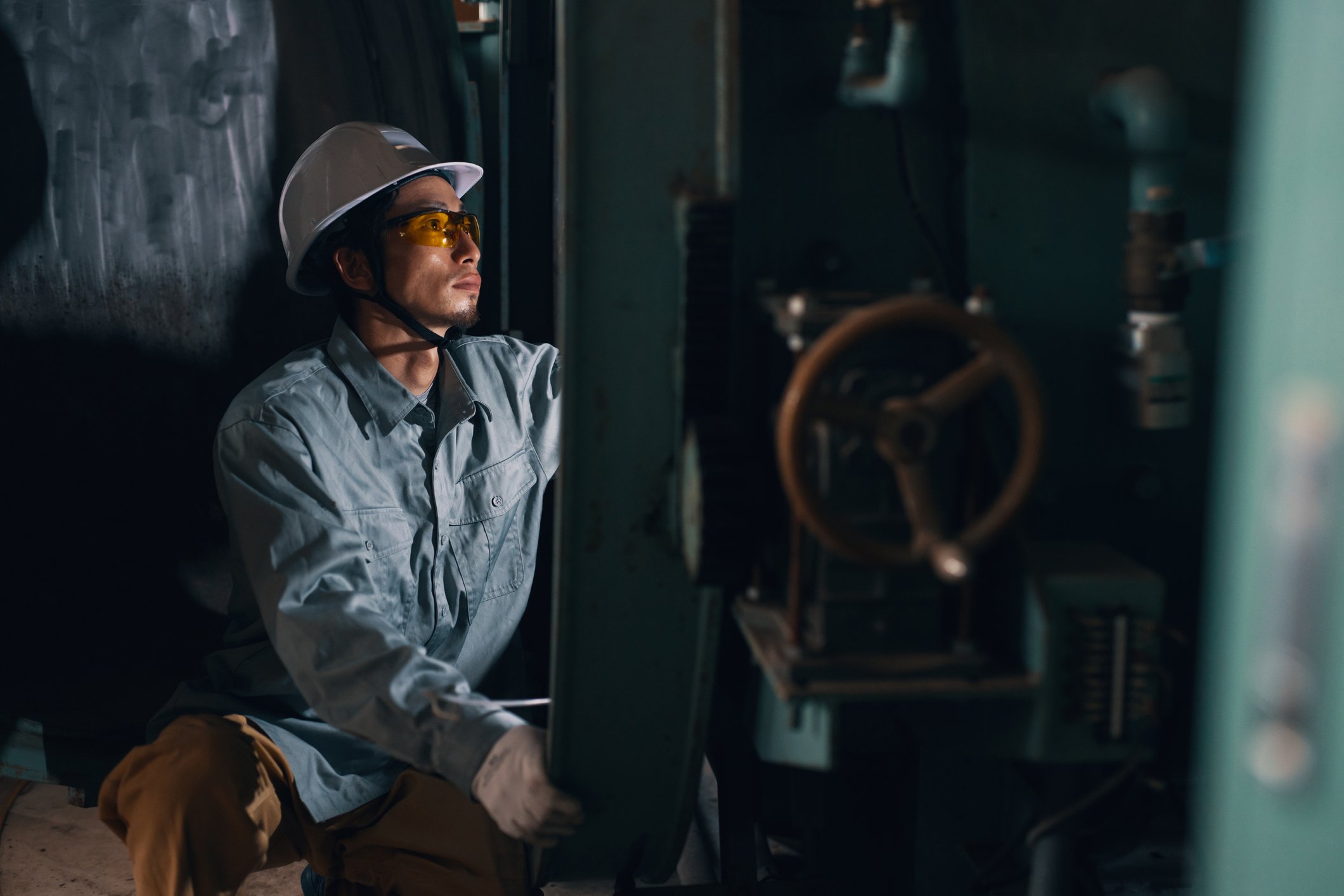 A person working on something at a manufacturing plant.