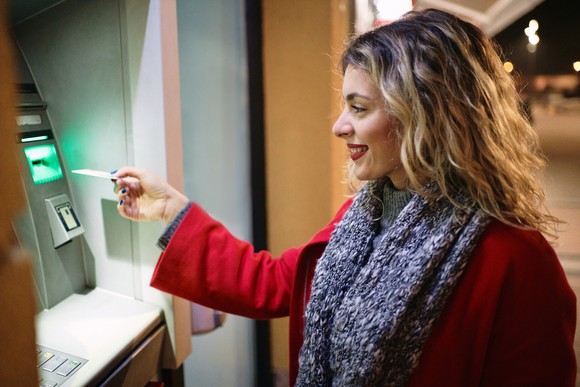 A woman uses an ATM.