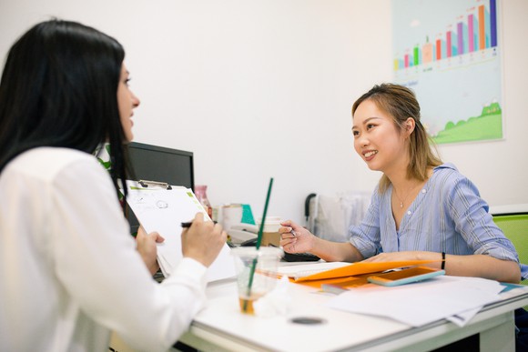 Two people discussing papers in a meeting.