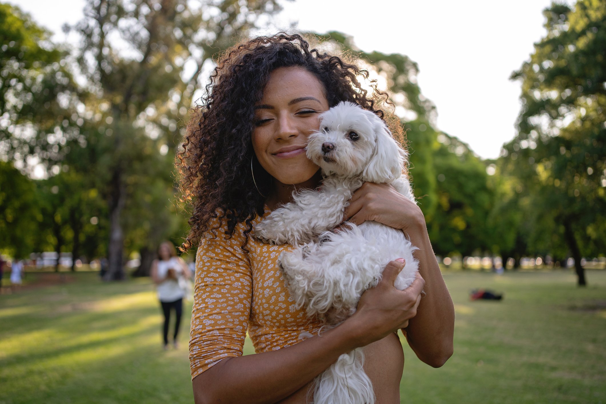 Young lady cuddling a small white dog