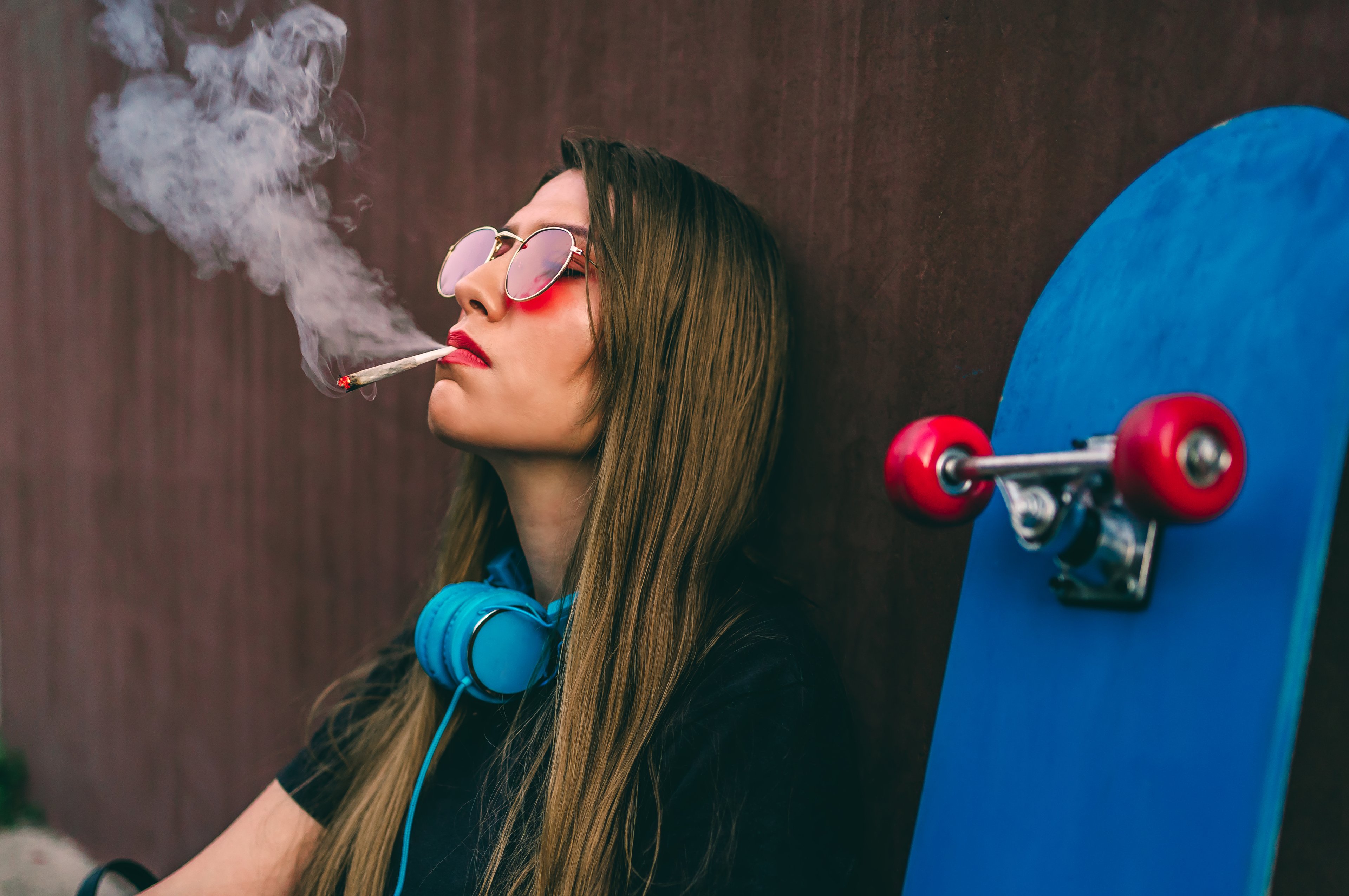 Person smoking a joint next to skateboard. 