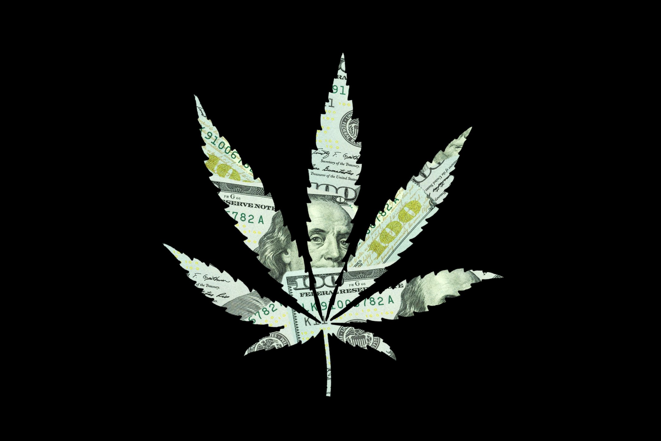 $100 bills are cut into the shape of a cannabis leaf.