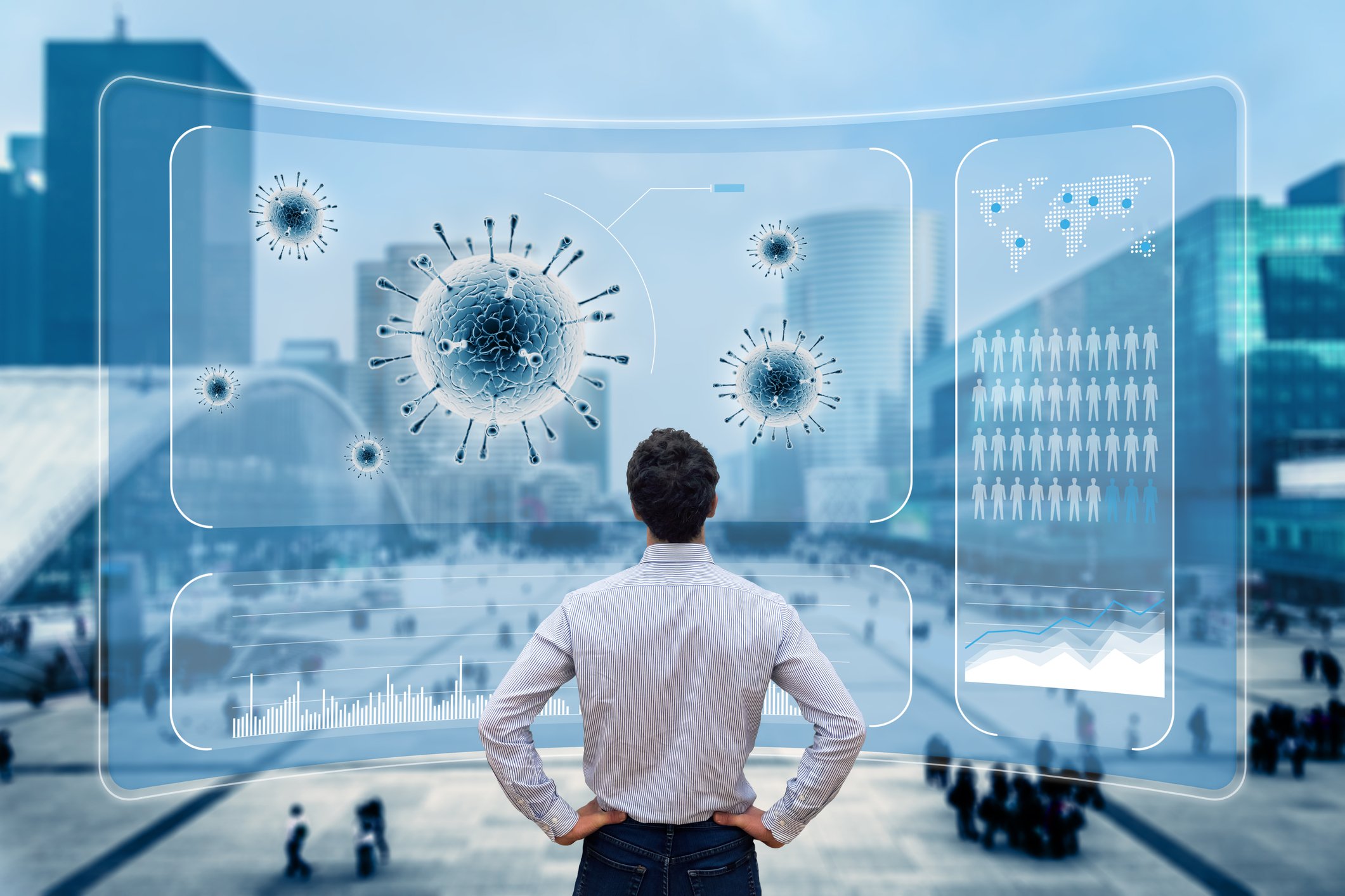 Person looking a a computer image of coronavirus with a city street in the background.