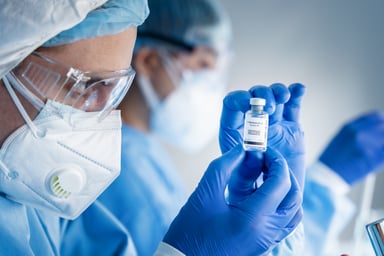 Scientists holding vaccine bottle