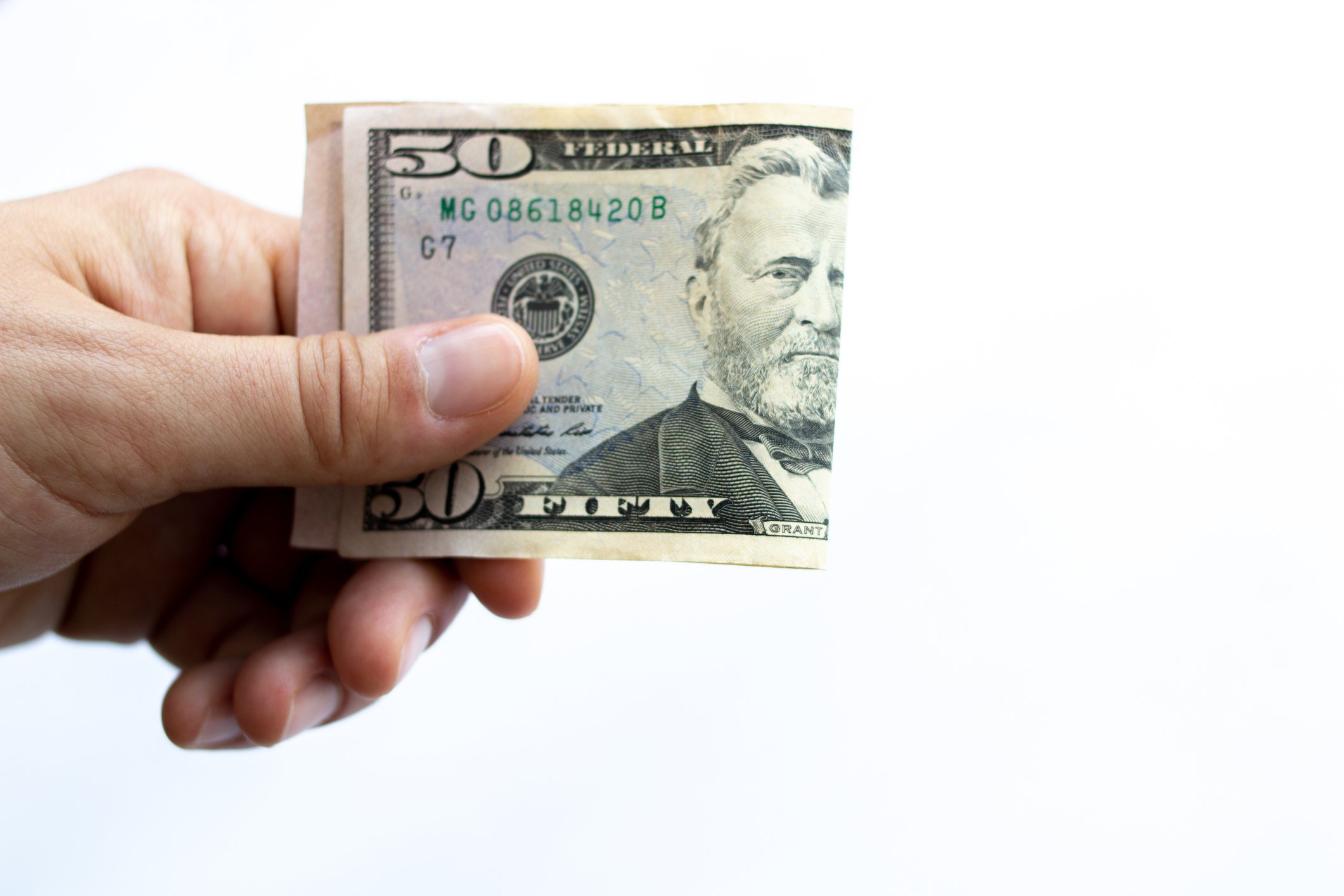 Hand holding $50 bill folded in half