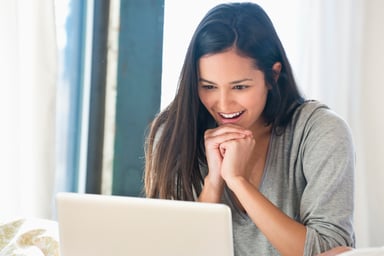 Young smiling woman looking at laptop