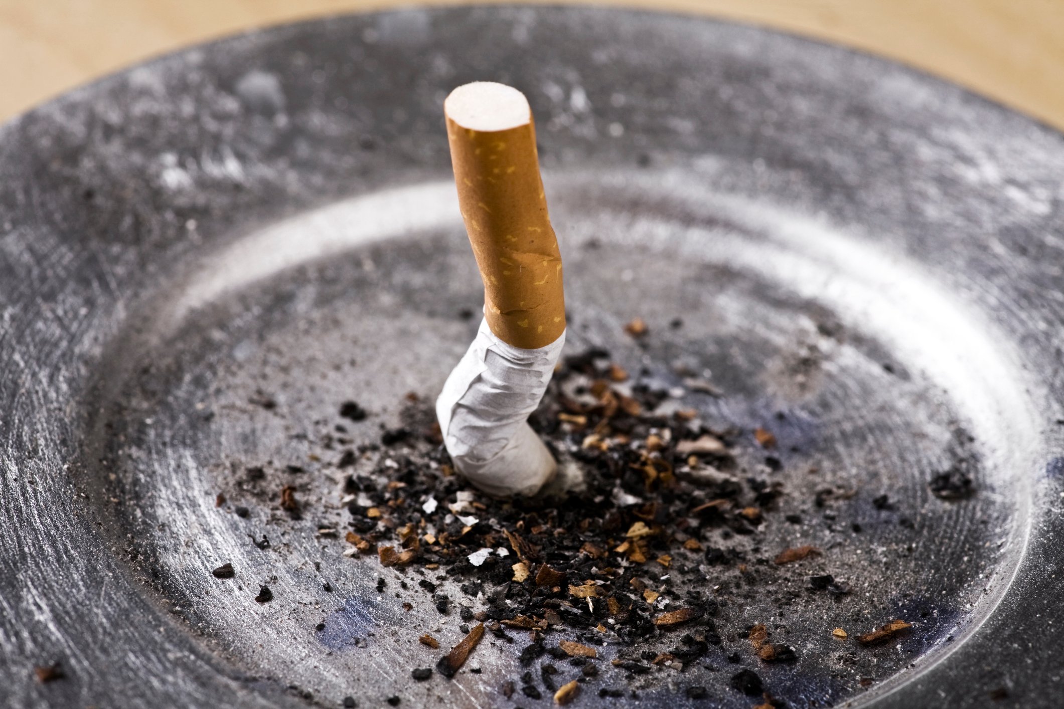 A cigarette butt smashed into an ash tray.