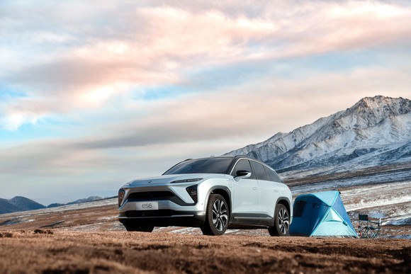 A NIO ES6, an upscale five-passenger electric SUV, at a mountain campsite.
