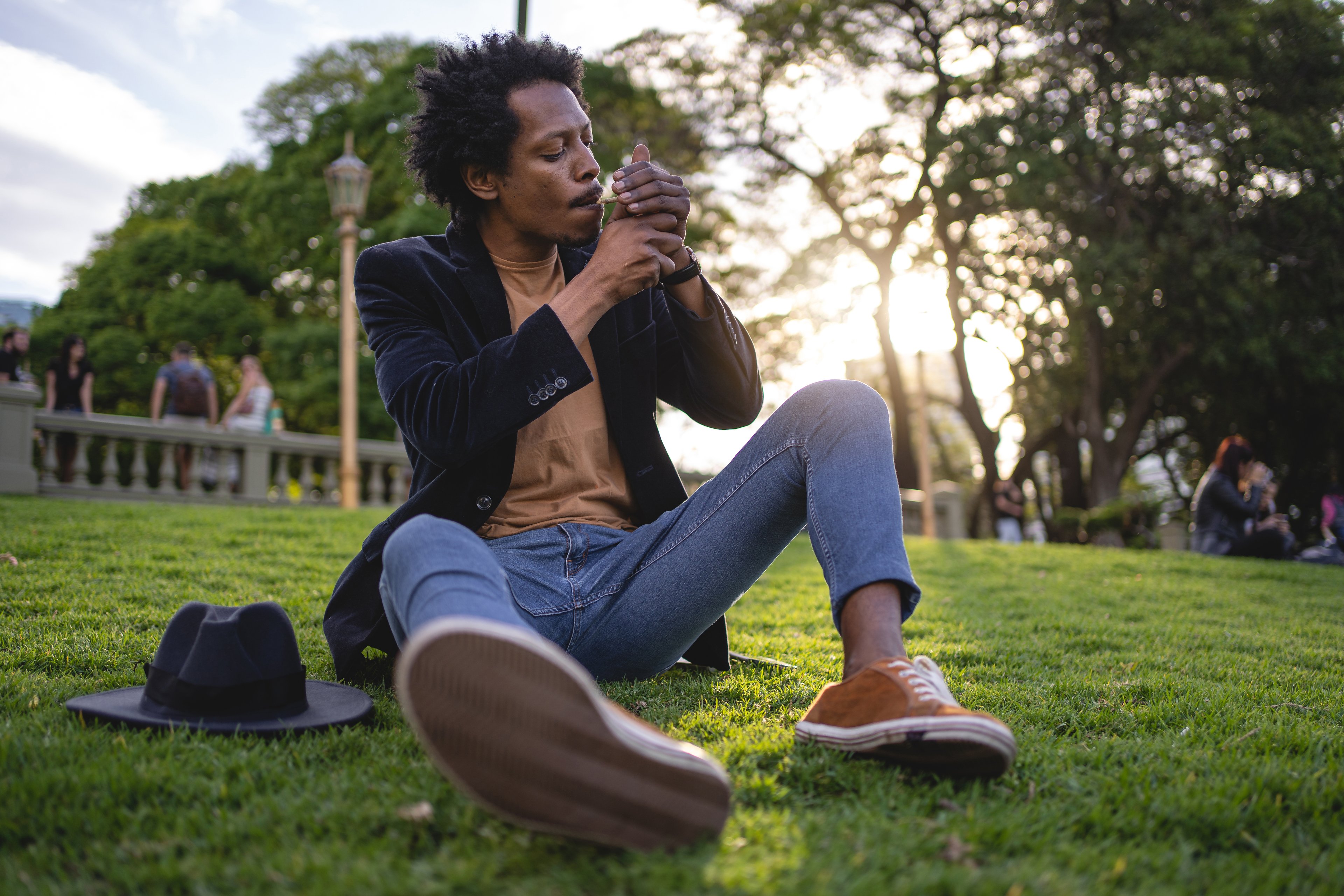 Man smoking cannabis while sitting in a park. 