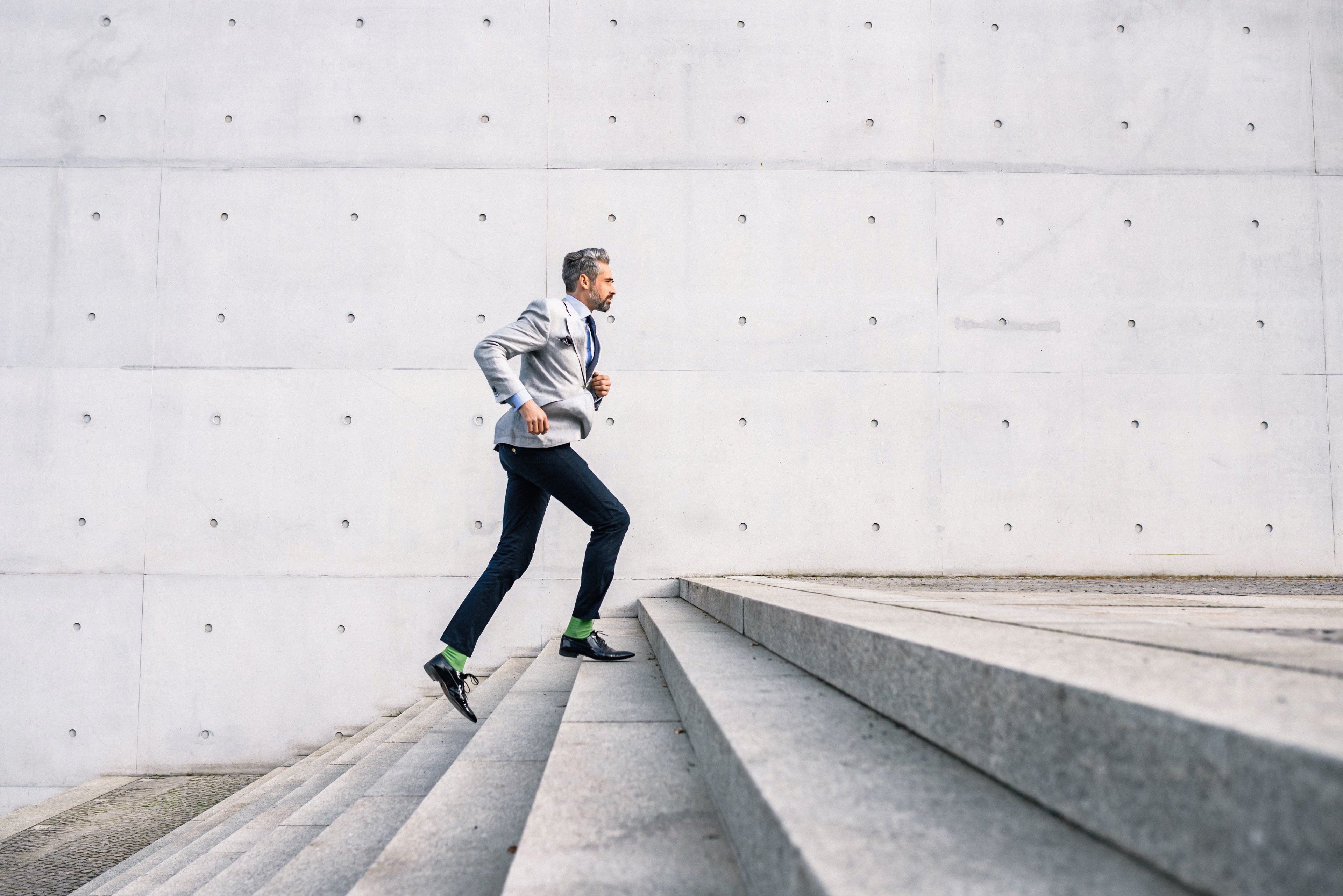 Business man climbing a set of stairs.