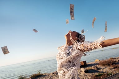 A person on a beach and money in the air.