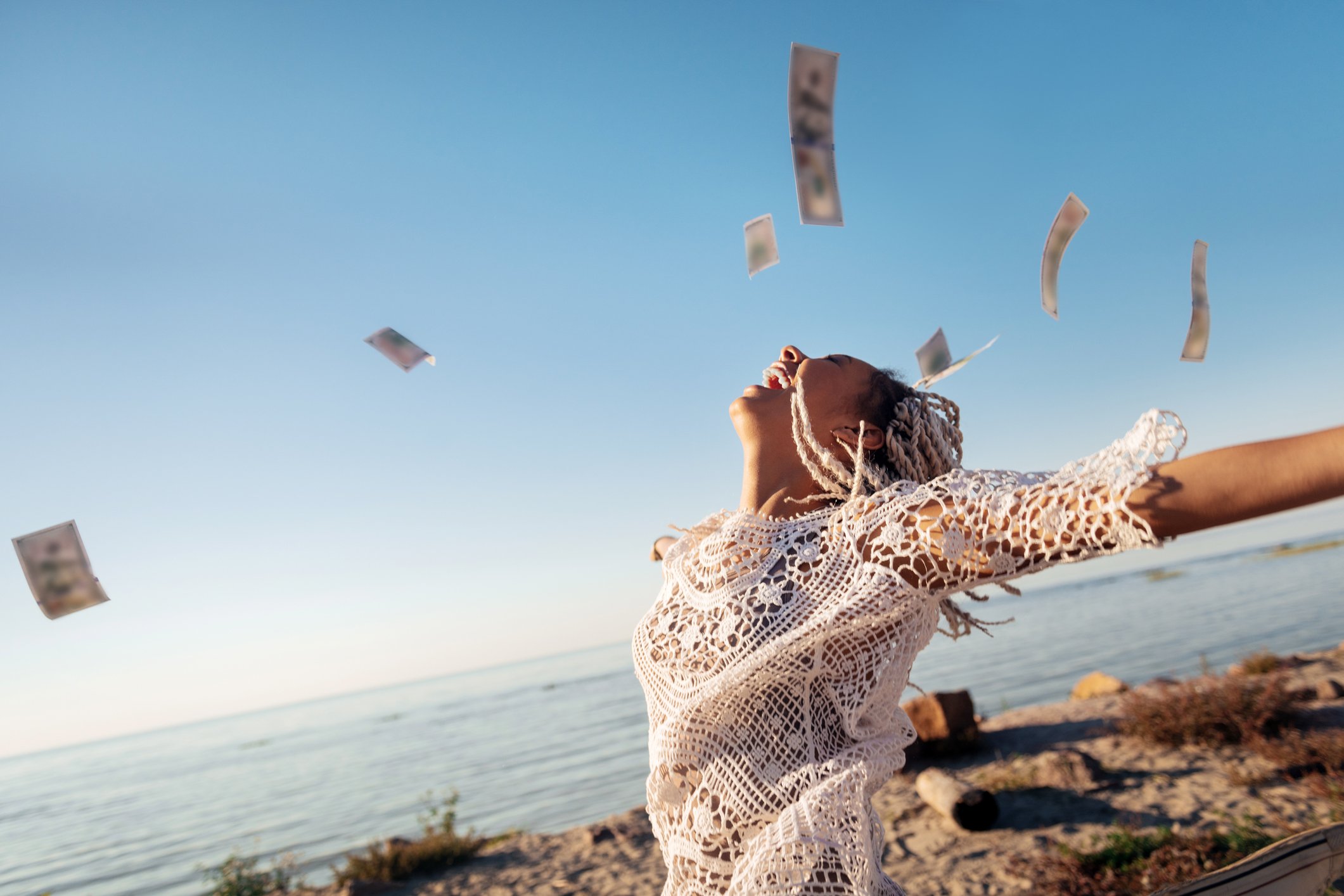 A person on the beach and money in the air.