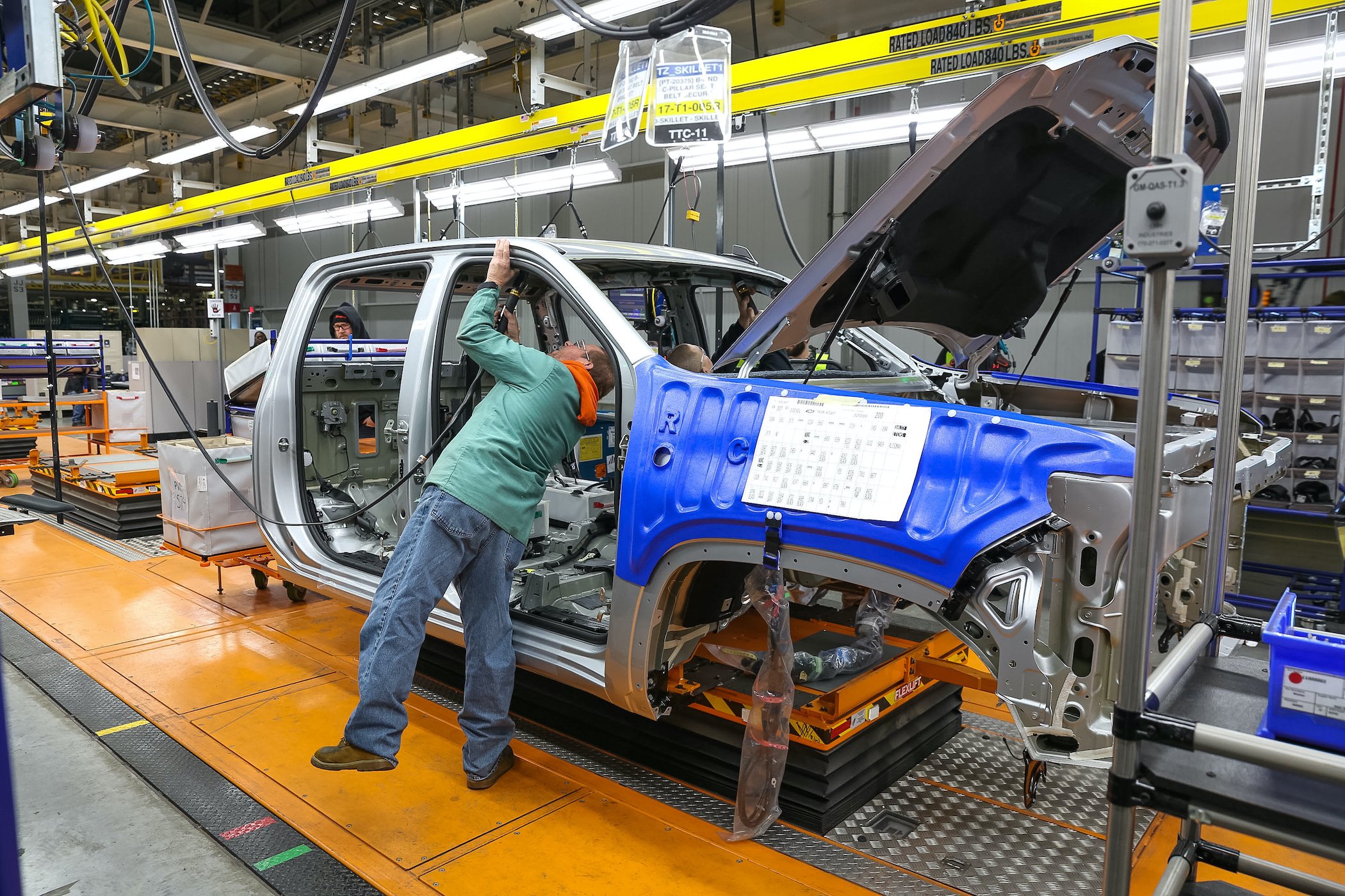 A worker tends to a partially-assembled heavy-duty GM pickup on the assembly line at GM's Flint, Michigan plant. 