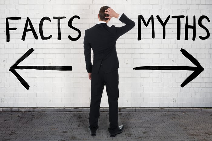 Person looking at opposing signposts reading Facts and Myths.