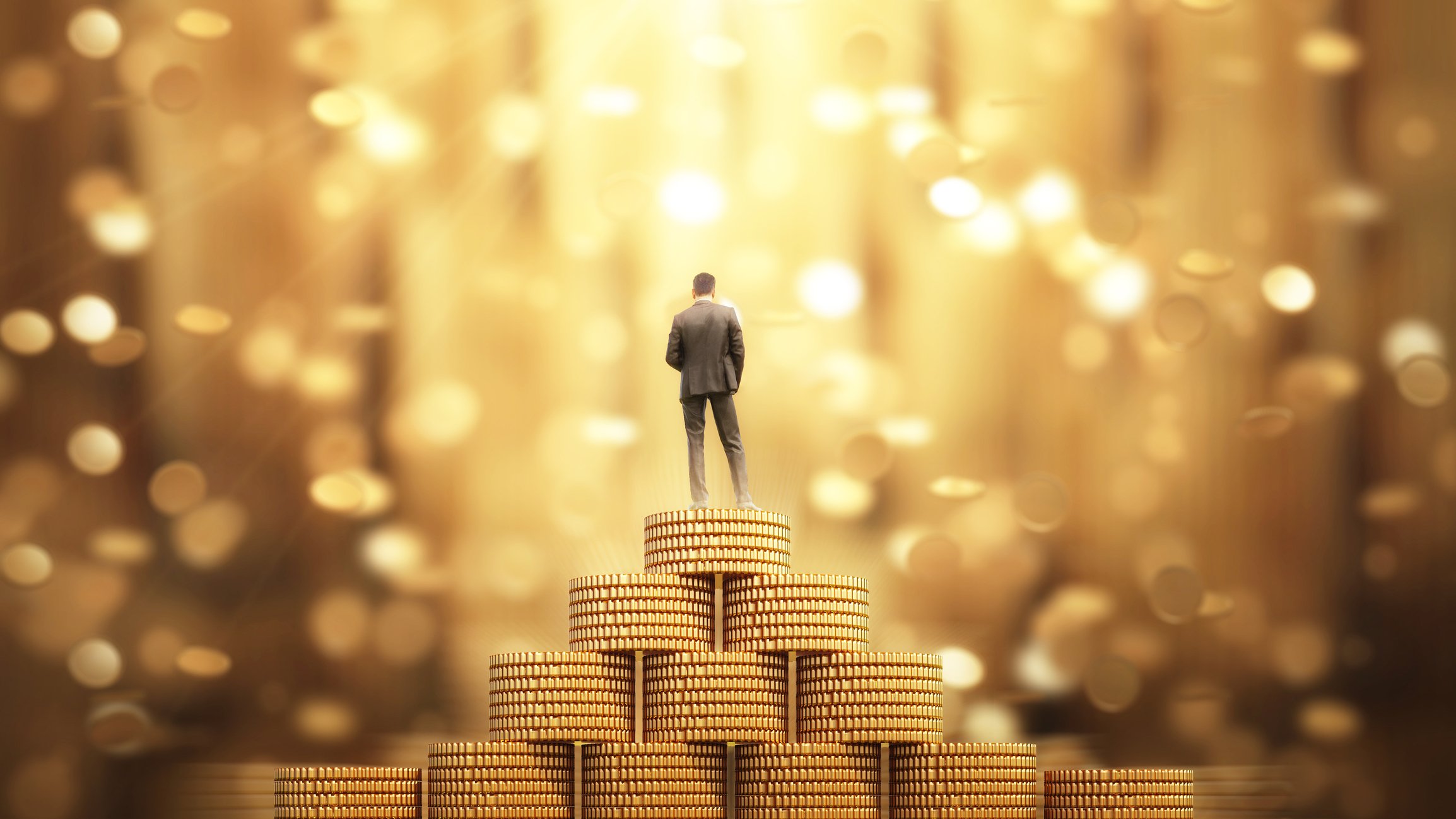 A person standing on a pyramid of gold coins.