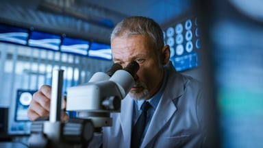 Scientist looking through microscope