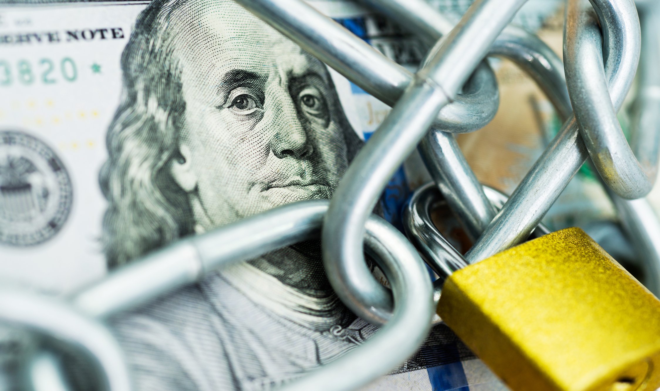 $100 bill with chain and lock.