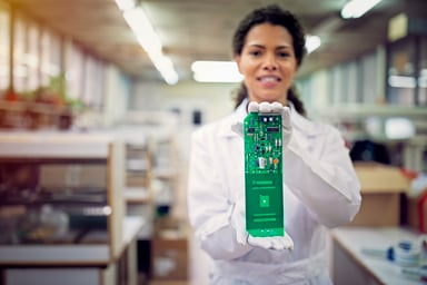 A person holding a circuit board.