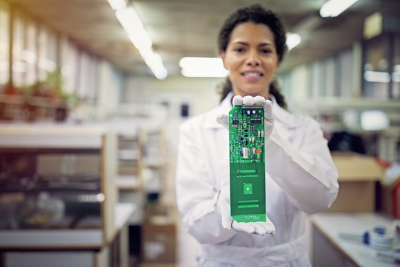 A person holding a circuit board.