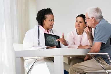 doctor showing brain image to two people