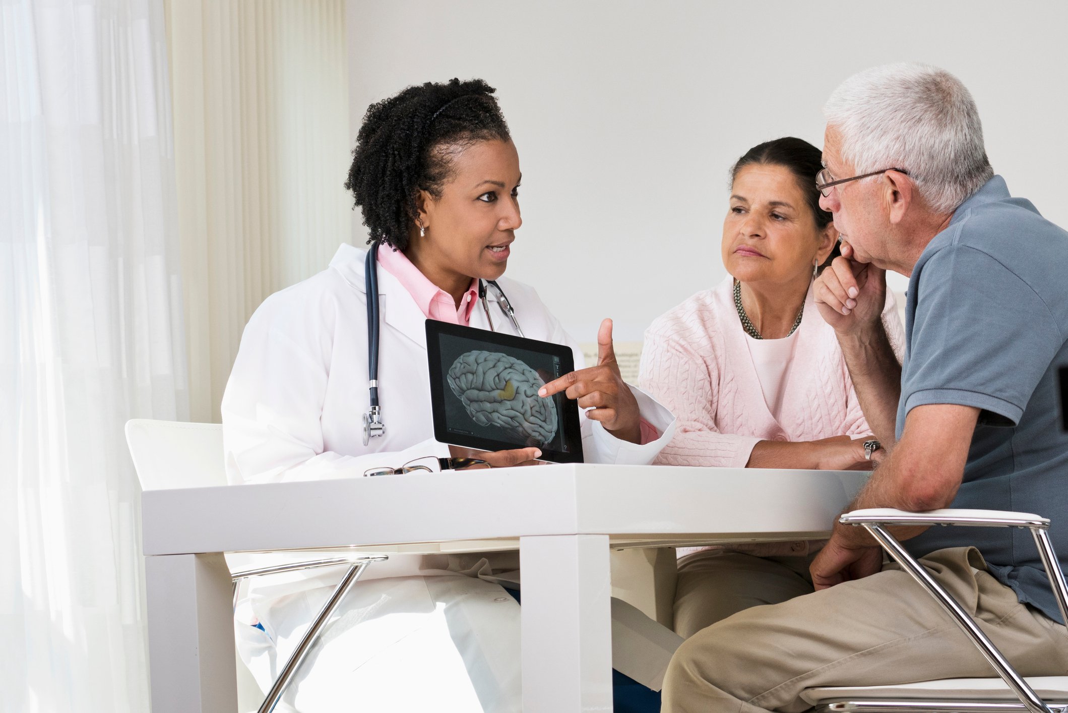 doctor showing brain image to two people