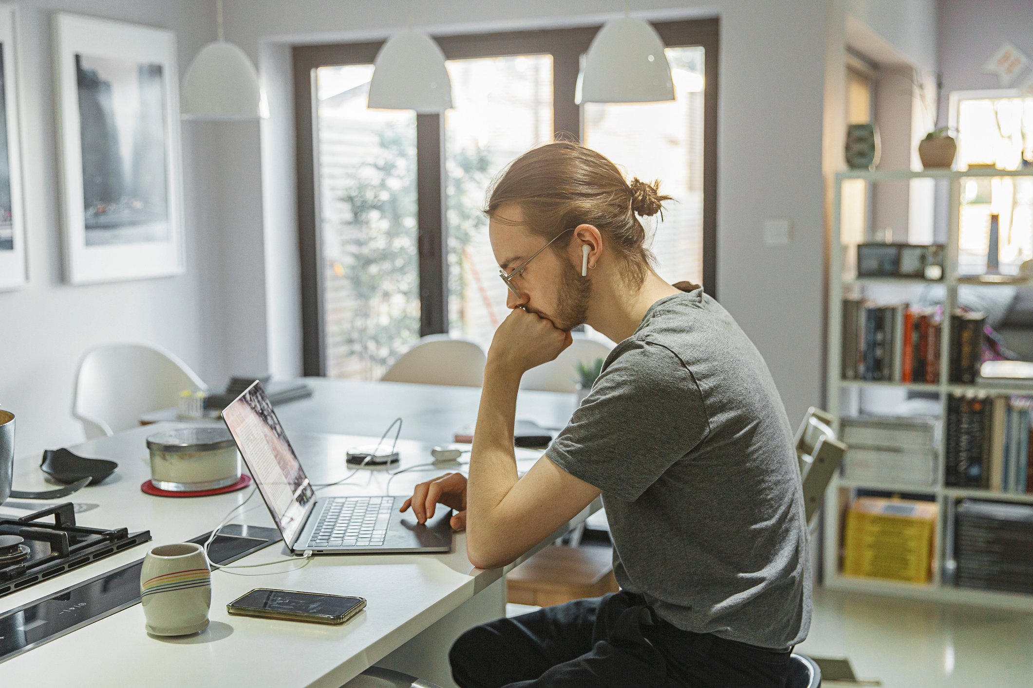 Man sitting in kitchen on laptop