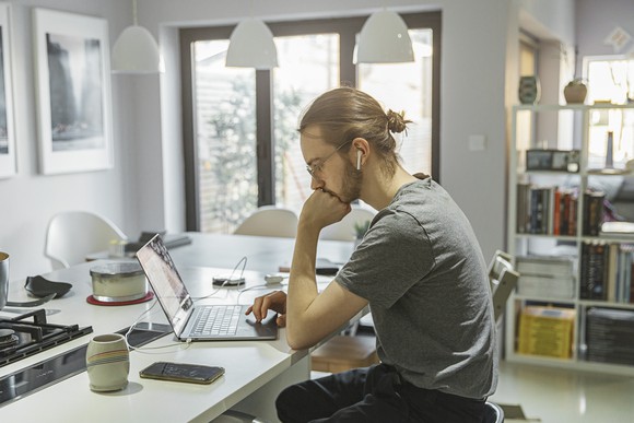 Man sitting in kitchen on laptop