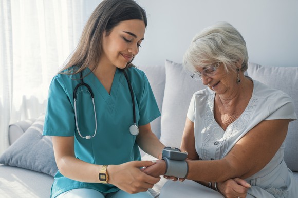 Nurse taking the blood pressure of patient. 