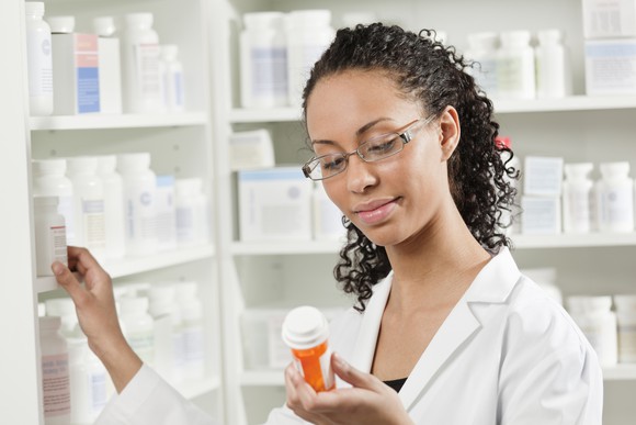 A pharmacist inspecting a pill bottle.
