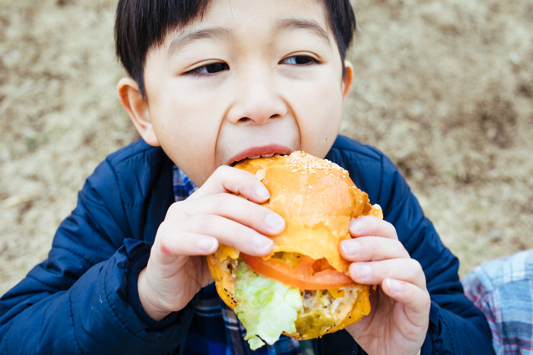 A child about to bite into a sandwich.