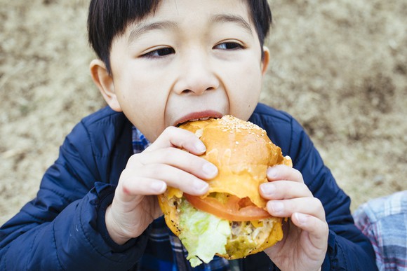 A child about to bite into a sandwich.