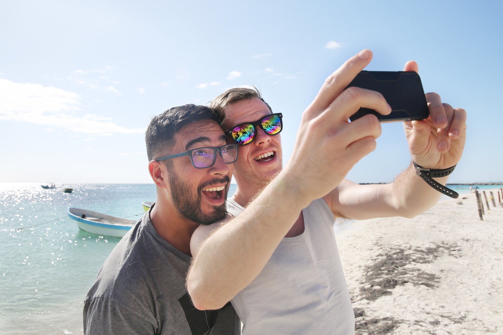 Two people taking a selfie at the beach.