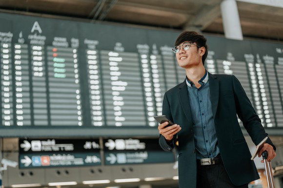 A man with a smartphone in an airport.