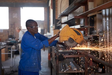 Person cuting steel pipes in a factory